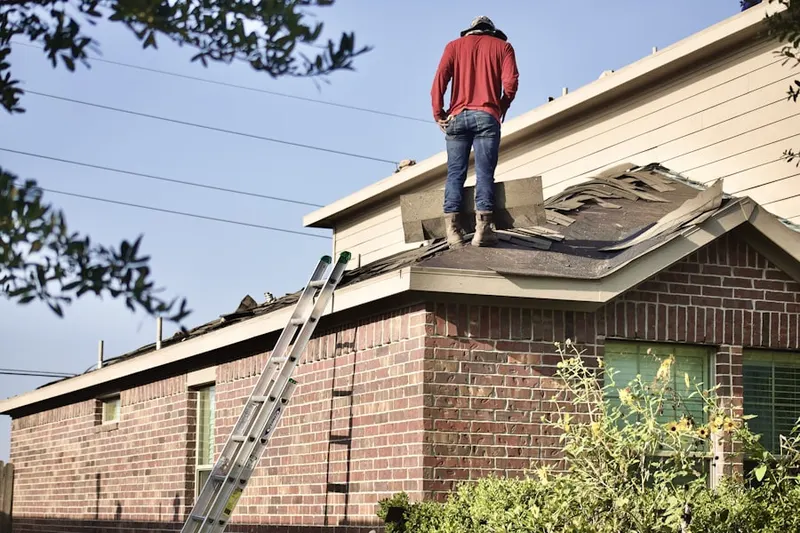Professional roofer working on a residential roof in Highland Falls